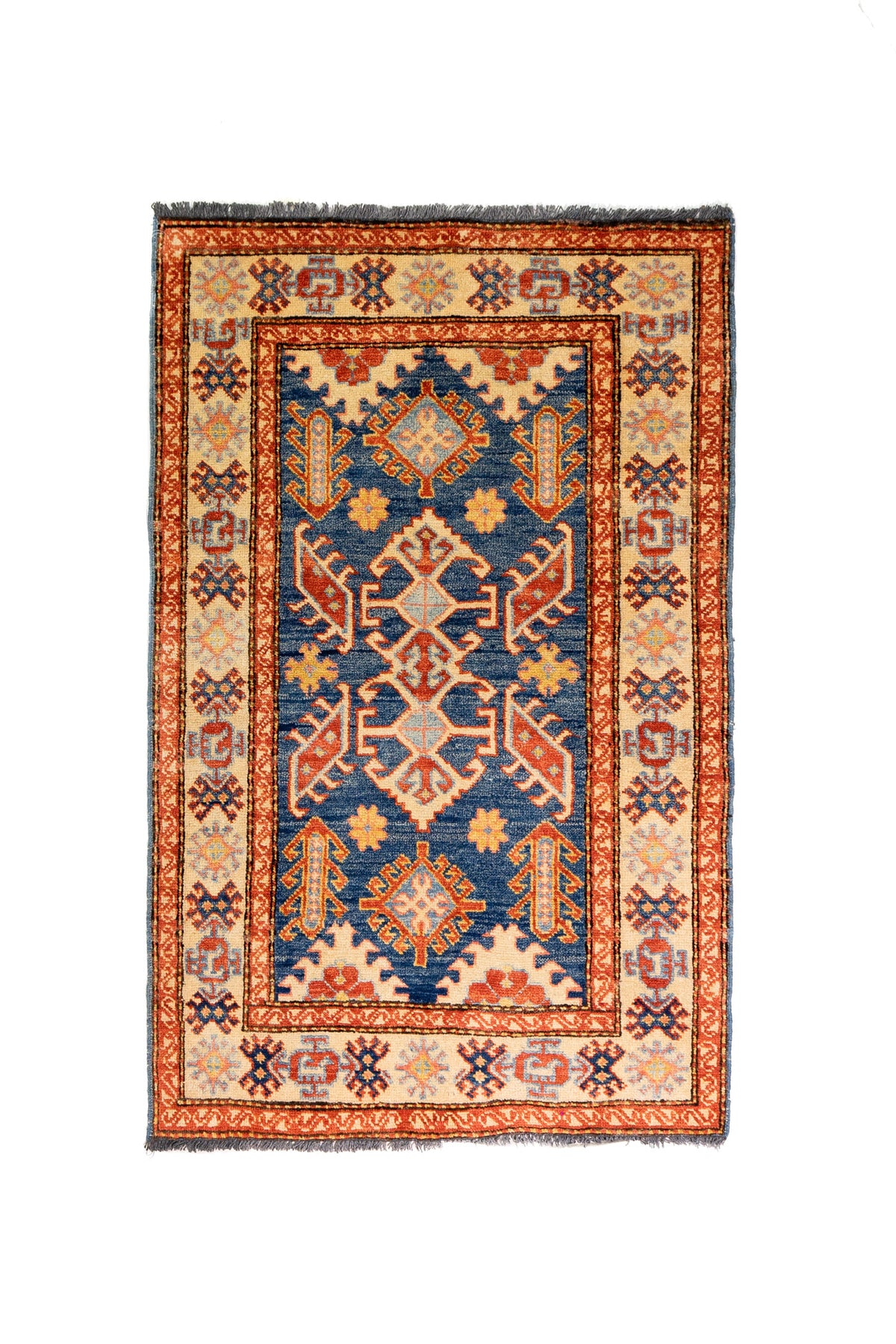 Alfombra Caucasica Kazak beige y azul de 0.83 x 1.30 mts, vista completa vertical; el diseño muestra medallones geométricos azules sobre un campo beige con guardas de acento ladrillo