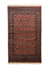 Alfombra Persa Bukara rojo de 0.92 x 1.55 mts, vista completa de la pieza con rombos rojos repetidos sobre un campo oscuro con guardas geométricas de contraste