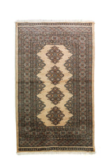 Alfombra Persa Bukara beige y gris de 0.95 x 1.55 mts, vista completa de la pieza con medallones geométricos repetidos y guardas múltiples que ordenan visualmente el campo central