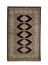 Alfombra Persa Bukara negro y beige de 0.94 x 1.52 mts, vista completa de la pieza con medallones geométricos repetidos y guardas múltiples que ordenan visualmente el campo central