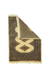 Alfombra Persa Bukara beige de 0.61 x 0.84 mts, vista con una esquina doblada para mostrar guarda, reverso y estructura visual
