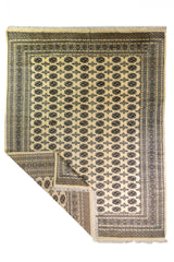 Alfombra Persa Bukara beige de 2.88 x 3.68 mts, vista completa con una esquina doblada; se observan medallones ovalados repetidos y guardas geométricas