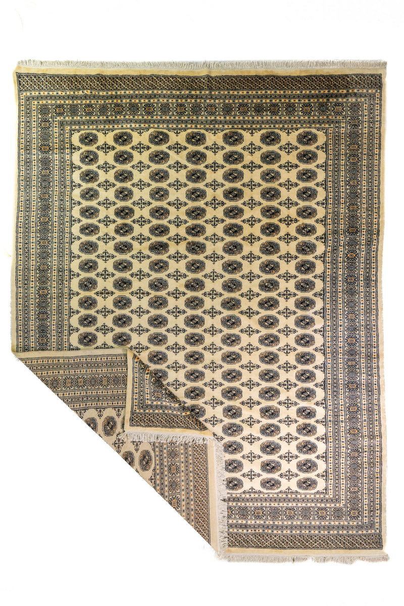 Alfombra Persa Bukara beige de 2.88 x 3.68 mts, vista completa con una esquina doblada; se observan medallones ovalados repetidos y guardas geométricas