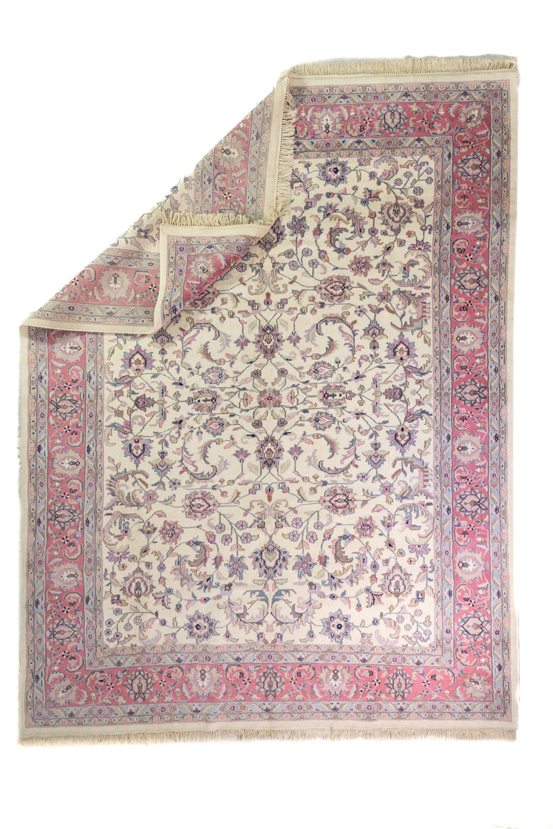 Alfombra Persa Nain rosa de 2.72 x 3.58 mts, vista completa con una esquina doblada; se observan motivos florales distribuidos en el campo y guardas ornamentales