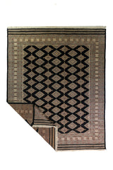 Alfombra Persa Bukara Yamouth negro de 2.03 x 3.10 mts, vista completa con una esquina doblada; se observan rombos claros repetidos sobre campo oscuro y guarda ornamental