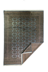Alfombra Persa Bukara Yamouth celeste de 2.48 x 3.38 mts, vista completa con una esquina doblada; se observan medallones geométricos repetidos y guardas definidas