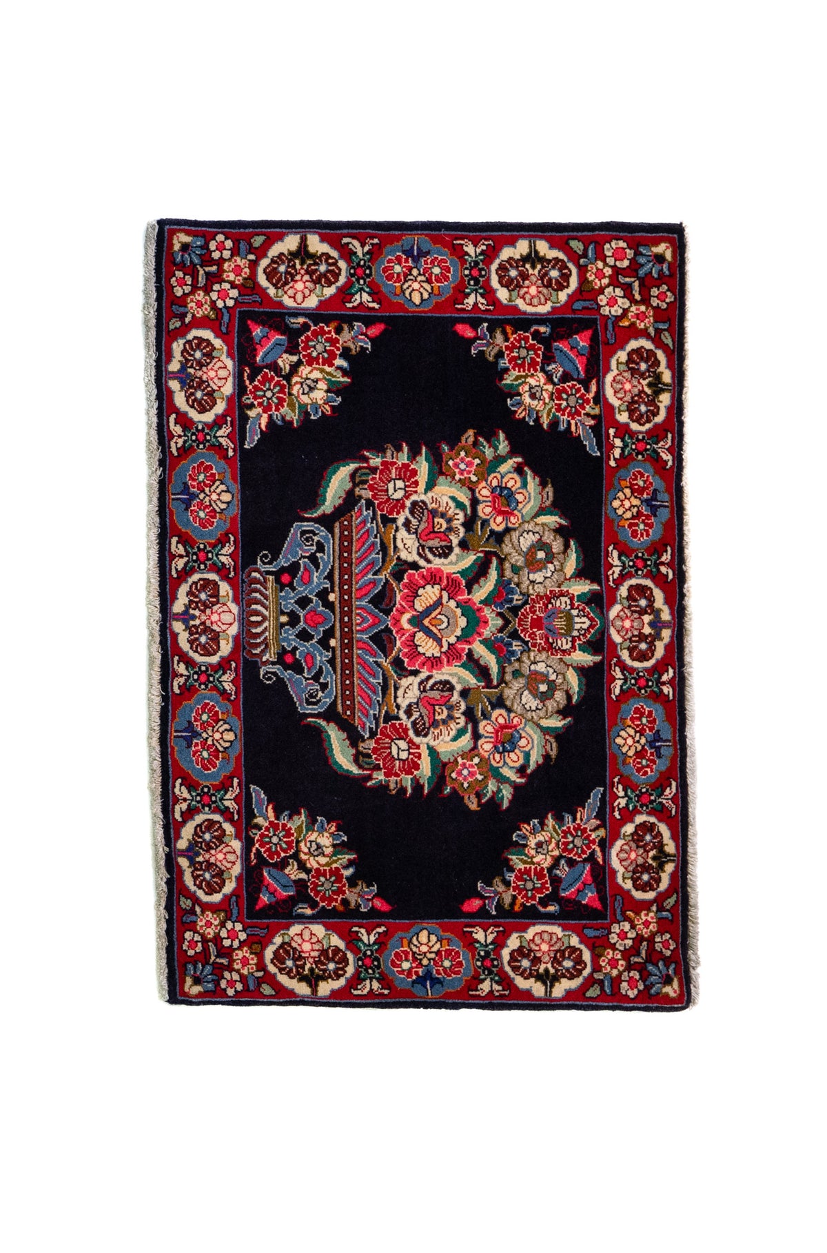 Alfombra Persa Horazan azul y rojo de 0.72 x 1.02 mts, vista completa de la pieza con un gran medallón floral sobre un campo azul oscuro, acompañado por una guarda roja y motivos vegetales