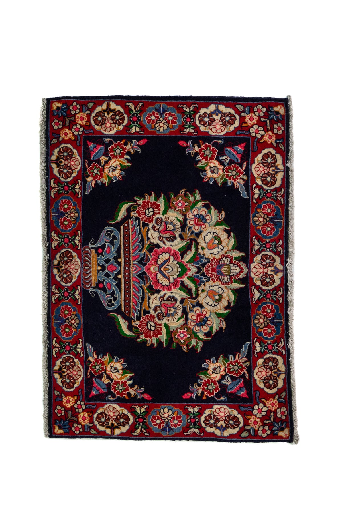 Alfombra Persa Sarouk azul y rojo de 0.69 x 1.05 mts, vista completa de la pieza con un medallón floral central sobre un campo azul oscuro, rodeado por una guarda roja de motivos vegetales