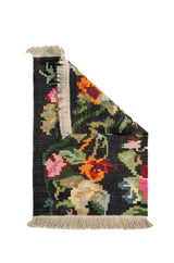 Alfombra Kilim verde de 0.60 x 0.90 mts, vista con una esquina doblada para mostrar guarda, reverso y estructura visual