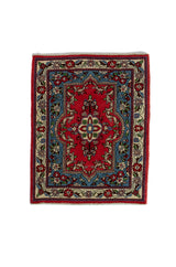 Alfombra Persa Sarouk rojo y celeste de 0.85 x 0.69 mts, vista completa de la pieza con un medallón central rojo y celeste rodeado por motivos florales y una guarda ornamental
