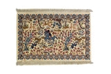 Alfombra Persa Tabriz blanco de 0.62 x 0.94 mts, vista completa de la pieza con una escena figurativa rodeada por abundantes motivos vegetales y una guarda decorativa