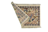 Alfombra Persa Tabriz blanco de 0.62 x 0.94 mts, vista con una esquina doblada para mostrar guarda, reverso y estructura visual
