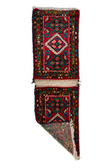 Alfombra Persa Hamadan rojo de 0.49 x 0.78 mts, vista con una esquina doblada para mostrar guarda, reverso y estructura visual