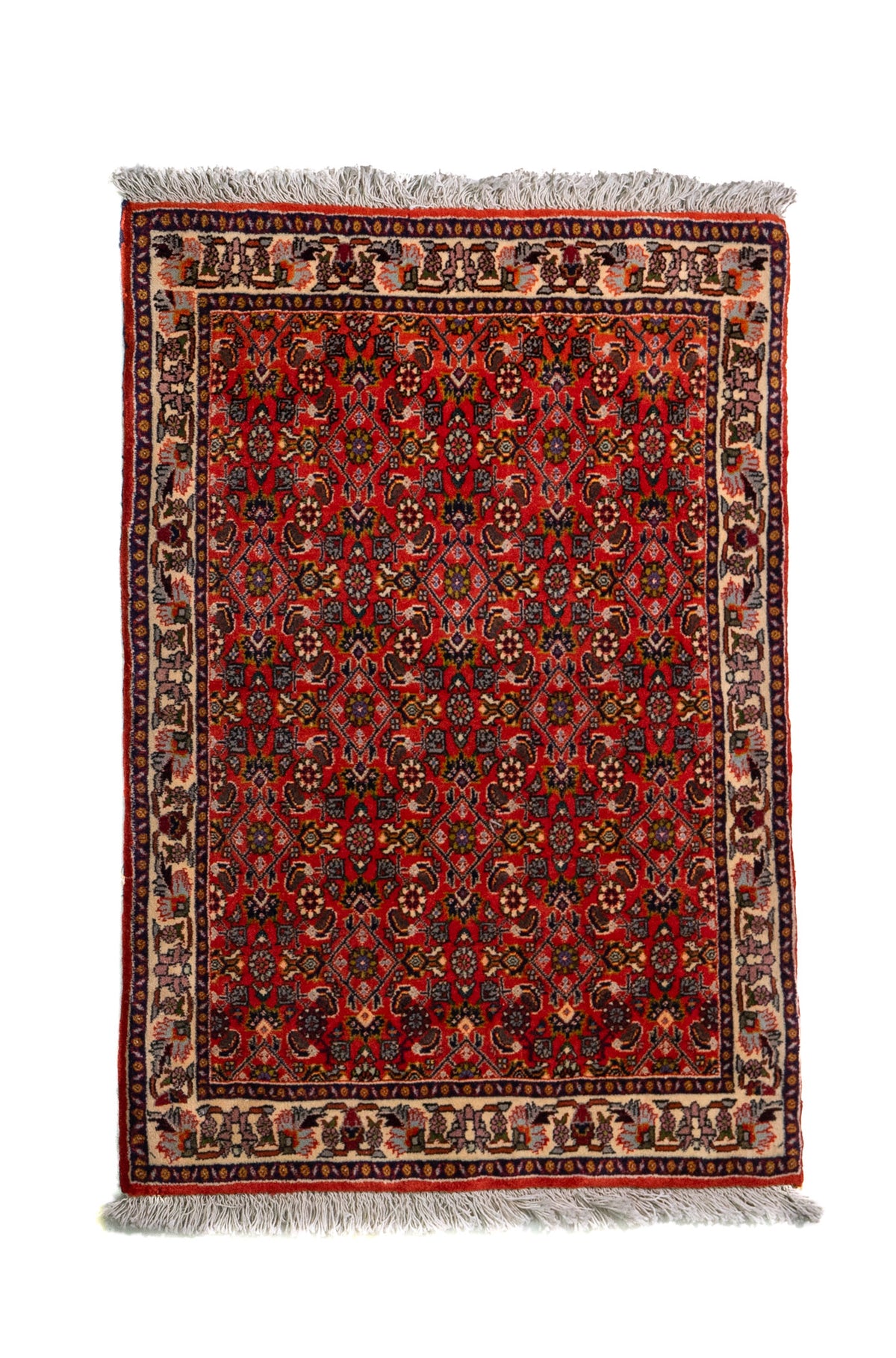 Alfombra Persa Horazan rojo y beige de 0.48 x 0.69 mts, vista completa de la pieza con pequeños motivos repetidos sobre un campo rojo, acompañados por guardas beige de inspiración tradicional