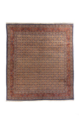 Alfombra oriental de gran formato con fondo marfil, diseño repetitivo minucioso y guarda roja con detalles azules.