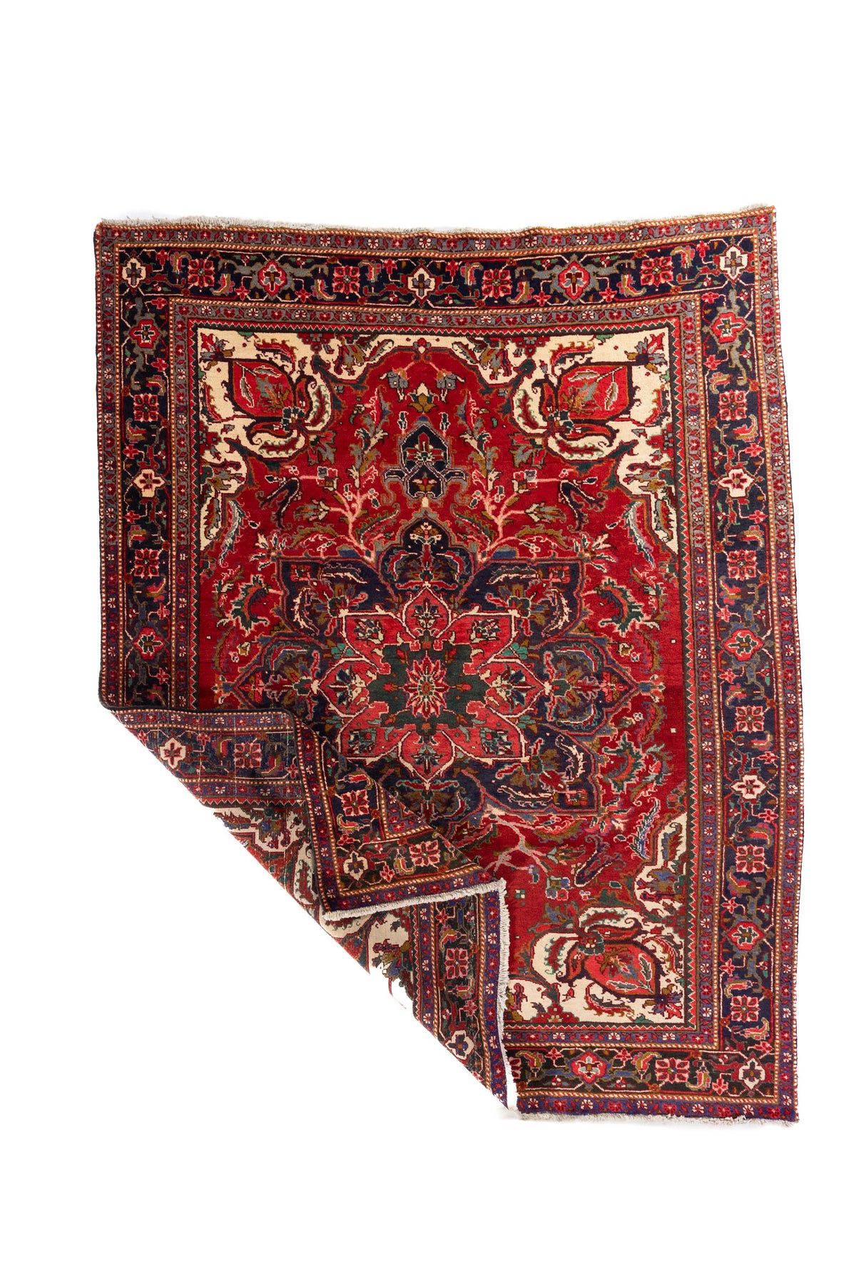 Alfombra clásica roja con una esquina levantada, mostrando el reverso, el espesor del tejido y el acabado con flecos.
