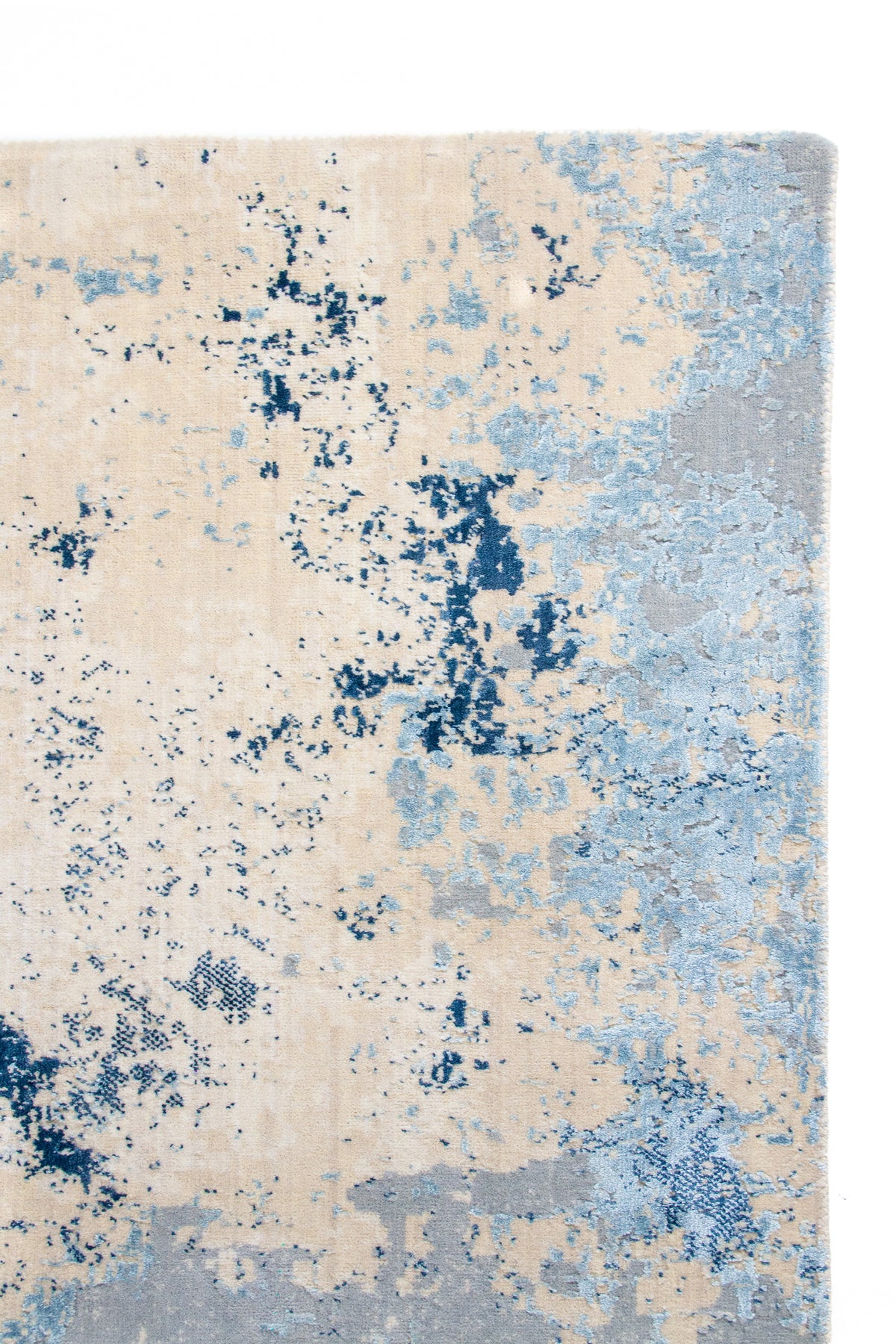 Detalle de borde y textura de alfombra Horizon Blue con diseño abstracto azul y beige