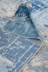 Detalle de doblez de alfombra Horizon Blue con diseño abstracto en tonos azules
