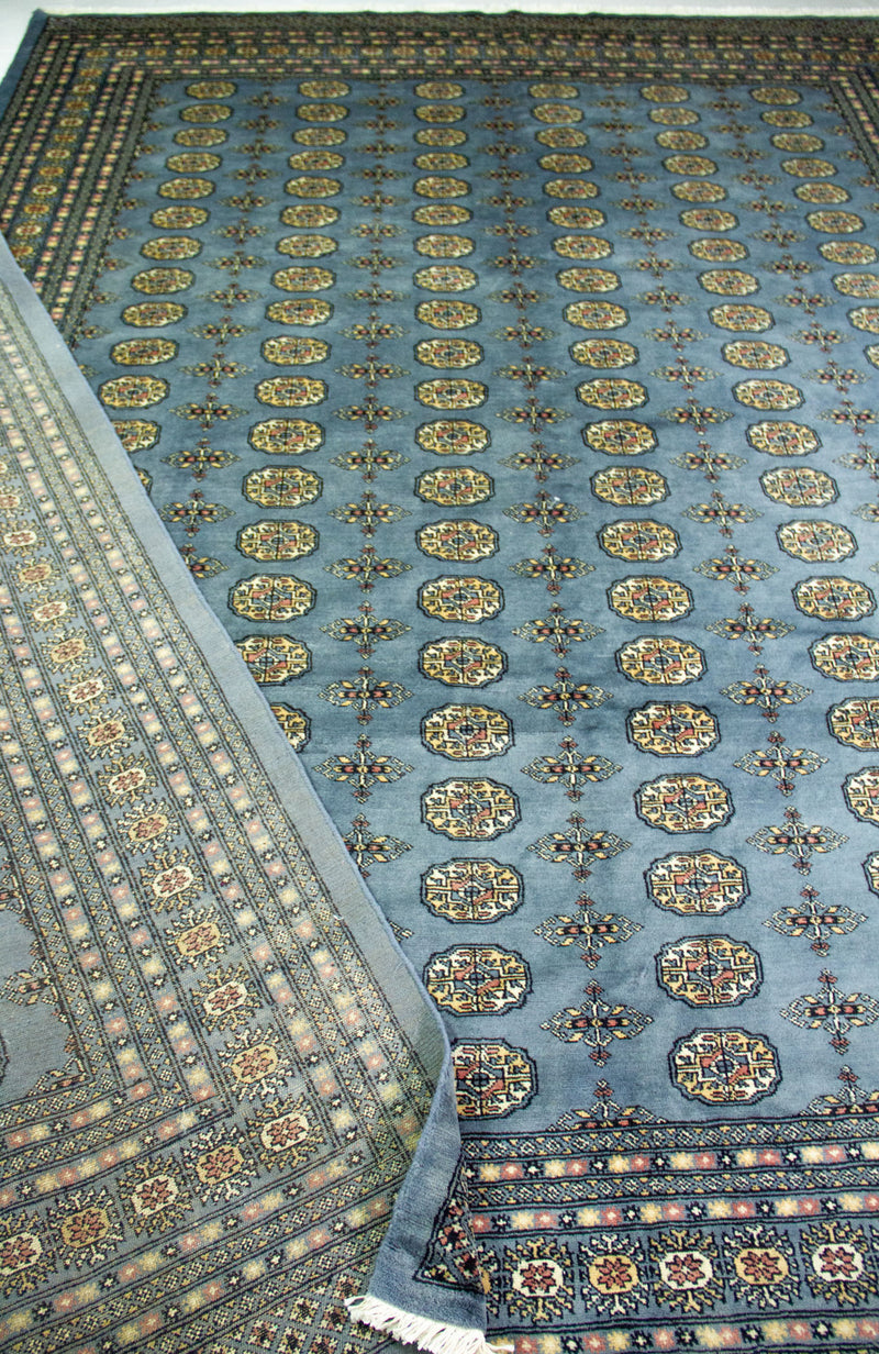 Vista en perspectiva de Alfombra Persa Bukara celeste de 2.77 x 3.75 mts con motivos geométricos repetidos