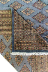 Detalle de superposición, guardas y motivos geométricos de Alfombra Persa Bukara celeste de 2.77 x 3.66 mts