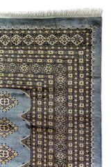 Alfombra Persa Bukara celeste de 2.52 x 3.61 mts, detalle de esquina y guarda geométrica; se observan motivos geométricos pequeños repetidos y guardas contrastantes