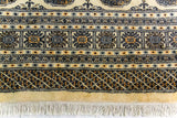 Alfombra Persa Bukara beige de 2.88 x 3.68 mts, detalle cercano de borde y flecos; se observan medallones ovalados repetidos y guardas geométricas