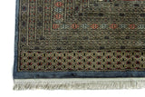 Alfombra Persa Bukara Yamouth celeste de 2.48 x 3.38 mts, detalle de guarda y flecos; se observan medallones geométricos repetidos y guardas definidas