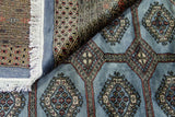 Alfombra Persa Bukara Yamouth celeste de 2.48 x 3.38 mts, detalle de pliegue, reverso y motivos; se observan medallones geométricos repetidos y guardas definidas