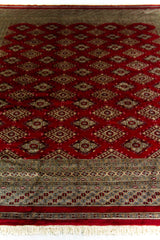 Alfombra Persa Bukara Yamouth rojo de 2.49 x 3.07 mts, detalle del patrón rojo y el borde; se observan retícula de rombos y motivos geométricos repetidos