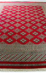 Alfombra Persa Bukara Yamouth rojo de 2.49 x 3.07 mts, detalle cercano del campo geométrico; se observan retícula de rombos y motivos geométricos repetidos