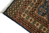 Alfombra Persa Bukara Yamouth celeste de 1.88 x 2.85 mts, detalle de esquina, borde y flecos; se observan motivos pequeños repetidos y guardas geométricas contrastantes