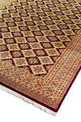 Alfombra Persa Bukara Yamouth beige de 1.88 x 2.60 mts, detalle de esquina y entramado geométrico; se observan entramado geométrico rojizo sobre campo claro