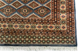Alfombra Persa Bukara Yamouth celeste de 1.88 x 2.87 mts, detalle de guarda y flecos; se observan rombos repetidos y guardas geométricas