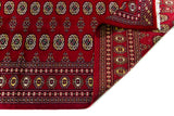 Alfombra Persa Bukara rojo de 1.85 x 2.75 mts, detalle de pliegue, reverso y borde; se observan columnas de medallones ovalados y guardas geométricas