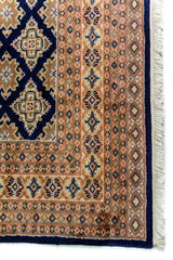 Alfombra Persa Yamouth azul de 1.85 x 2.85 mts, detalle de borde y flecos; se observan retícula de rombos azules sobre campo claro