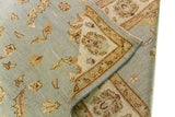 Alfombra Persa Isfahan celeste de 1.85 x 2.82 mts, detalle de pliegue, reverso y borde; se observan motivos florales y vegetales de tono suave con guardas claras