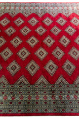 Alfombra Persa Yamouth rojo de 1.81 x 2.87 mts, detalle cercano del campo y los motivos; se observan medallones y rombos repetidos en una trama geométrica