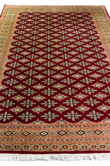 Alfombra Persa Yamouth rojo de 1.88 x 2.80 mts, vista en perspectiva del patrón geométrico; se observan retícula geométrica densa con guarda ornamental