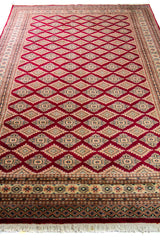 Alfombra Persa Yamouth beige y rojo de 1.88 x 2.82 mts, vista en perspectiva del campo y las guardas; se observan retícula borgoña sobre campo claro con guardas beige