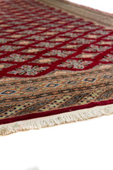 Alfombra Persa Yamouth rojo de 1.88 x 2.87 mts, vista en perspectiva del campo rojo; se observan retícula geométrica de motivos repetidos y guardas múltiples