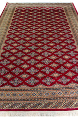 Alfombra Persa Yamouth rojo de 1.88 x 2.87 mts, detalle cercano del patrón y el borde; se observan retícula geométrica de motivos repetidos y guardas múltiples