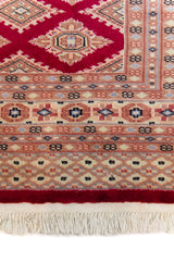 Alfombra Persa Yamouth rojo de 1.83 x 2.87 mts, detalle de guarda y flecos; se observan patrón geométrico repetitivo con guardas ornamentales