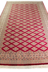 Alfombra Persa Yamouth rojo de 1.83 x 2.87 mts, vista en perspectiva del campo y el borde; se observan patrón geométrico repetitivo con guardas ornamentales