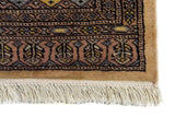 Alfombra Persa Yamouth beige de 1.55 x 2.44 mts, detalle de borde y flecos; se observan motivos geométricos alargados y guardas oscuras