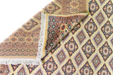 Alfombra Persa Yamouth beige de 1.55 x 2.54 mts, detalle de pliegue, reverso y patrón; se observan rombos repetidos y guardas geométricas de contraste
