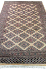 Alfombra Persa Yamouth marrón y beige de 1.60 x 2.54 mts, vista en perspectiva del campo oscuro; se observan retícula geométrica clara sobre campo oscuro