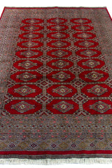 Alfombra Persa Yamouth rojo de 1.58 x 2.36 mts, vista en perspectiva del campo y las guardas; se observan medallones ovalados destacados y guardas rojizas