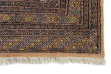 Alfombra Persa Yamouth marrón y beige de 1.52 x 2.44 mts, detalle de guarda y flecos; se observan grandes rombos claros y guardas oscuras