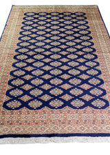 Alfombra Persa Yamouth azul de 1.55 x 2.54 mts, vista en perspectiva del campo y la guarda; se observan retícula geométrica azul sobre campo claro