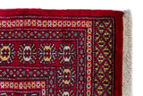 Alfombra Persa Bukara Yamouth rojo de 2.40 x 1.55 mts, detalle de guarda, borde y textura; el diseño muestra hileras de medallones ovalados sobre un campo rojo y guardas geométricas densas